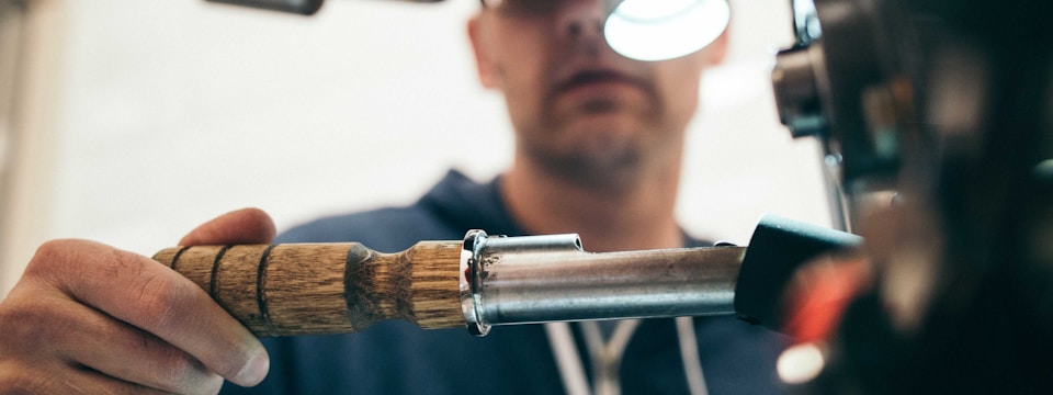 Person using a soldering iron on a wooden handle