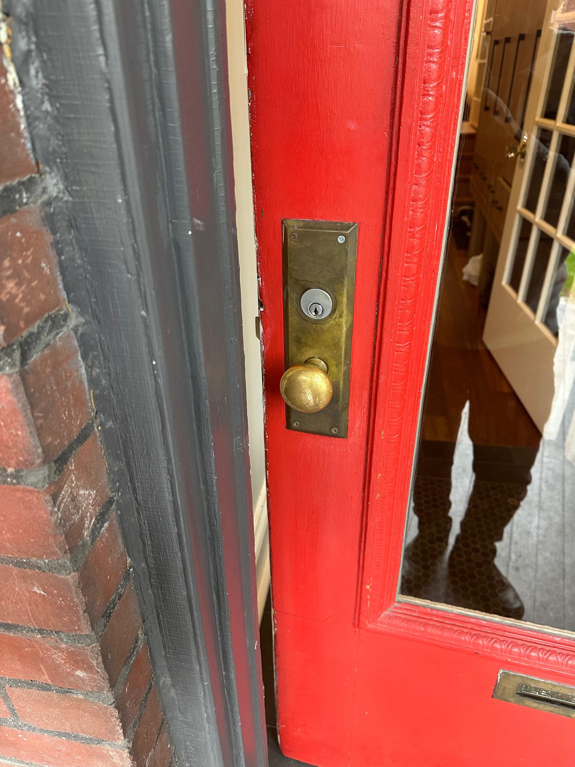 Brass lock hardware on a red entrance door
