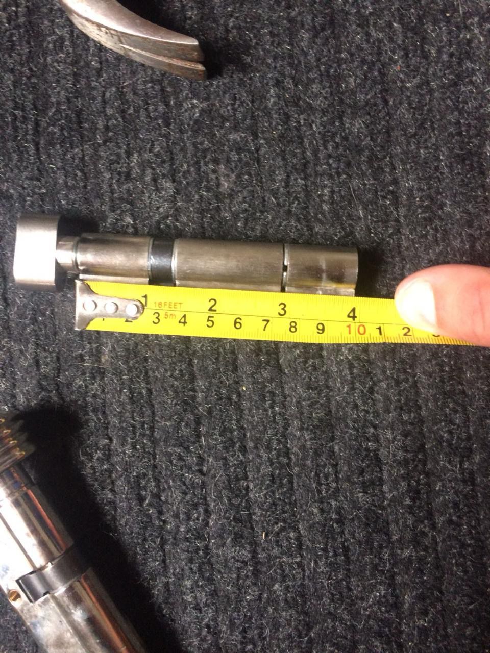 Lock cylinder being measured with a tape measure