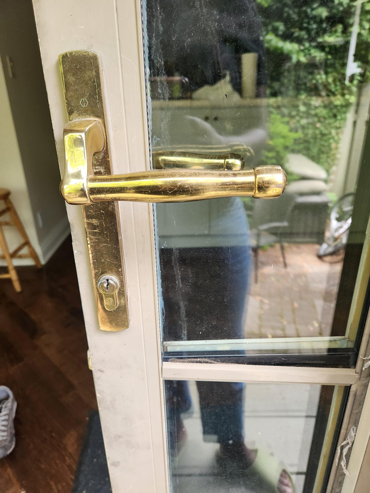Brass lever handle on a glass door seen from inside a room