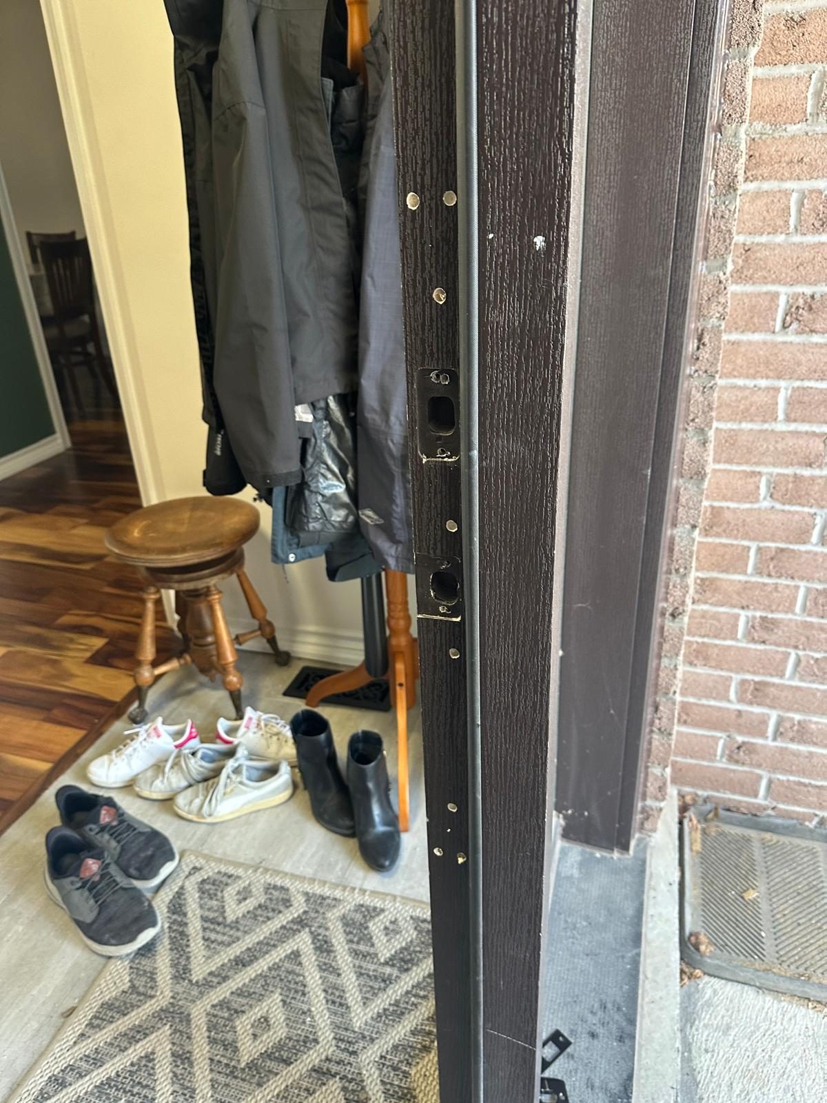 Door edge standing open into a hallway with coats hanging