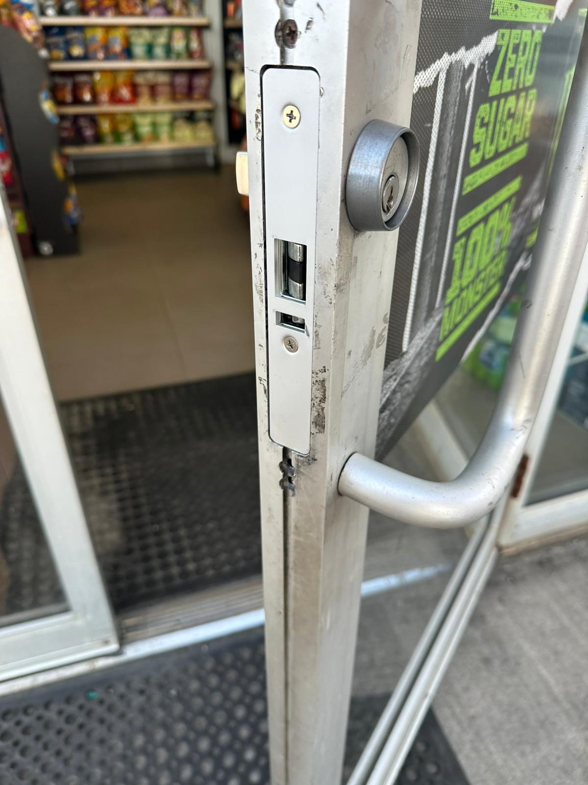 Cylinder in an aluminium storefront door with the shop interior behind