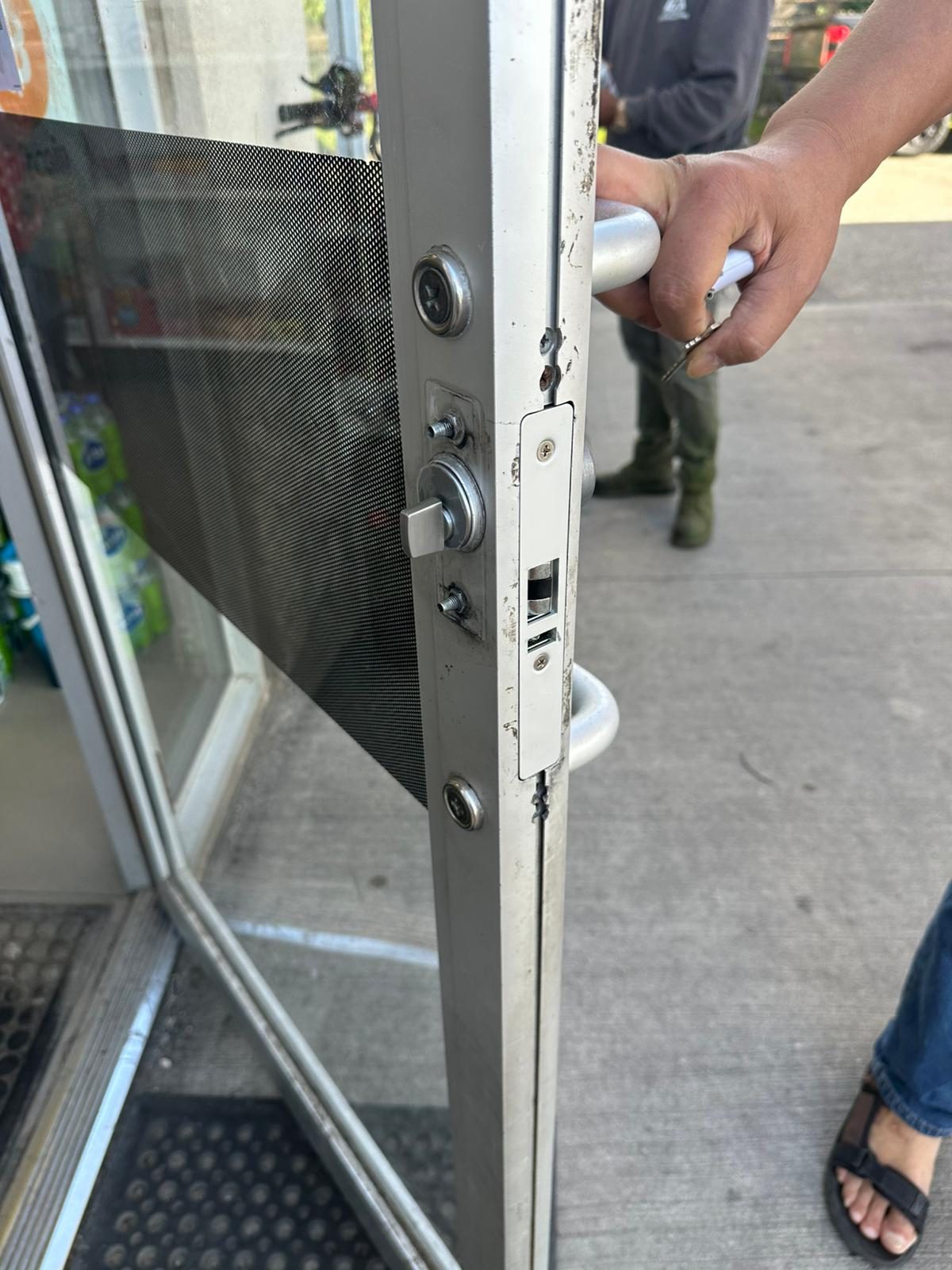 Technician working on the lock stile of a glass storefront door