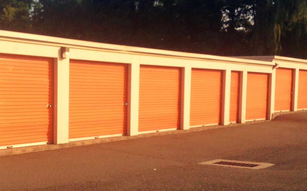 Row of self-storage units with orange roll-up doors