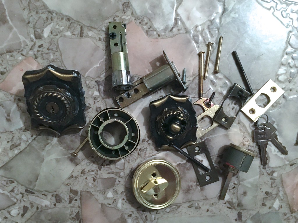Parts of a dismantled deadbolt laid out on a surface