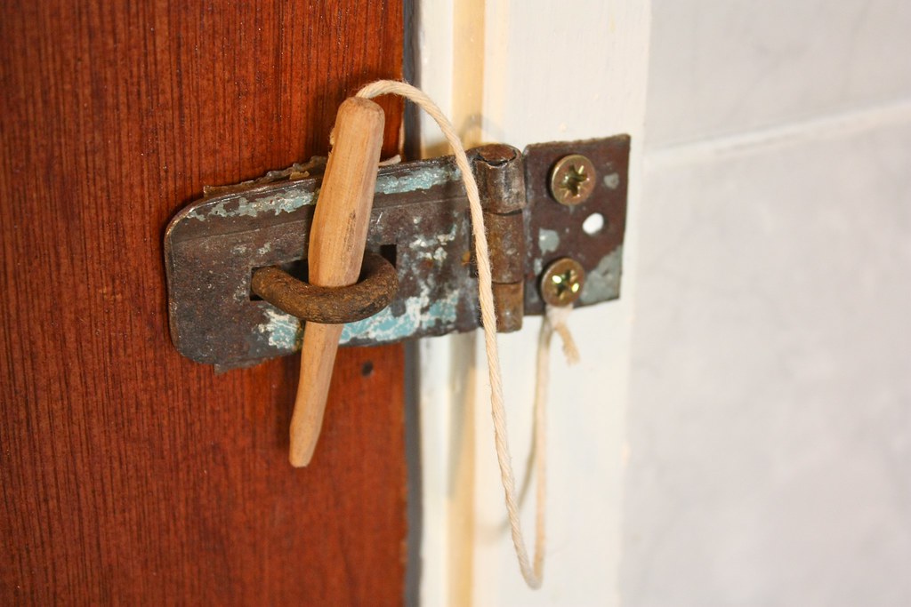 Old sliding bolt latch on the edge of an interior door