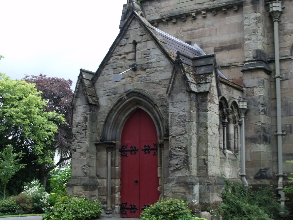 Stone church with a red arched front door